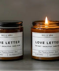 Two candles labeled 'Love Letter' by Isle of Rose Candle Co on a dark background.