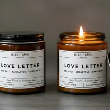Two candles labeled 'Love Letter' by Isle of Rose Candle Co on a dark background.
