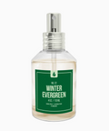 Clear spray bottle labeled 'Winter Evergreen' on a white background
