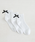 White socks with black bows on a light gray background