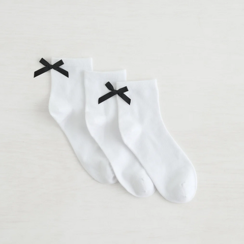 White socks with black bows on a light gray background