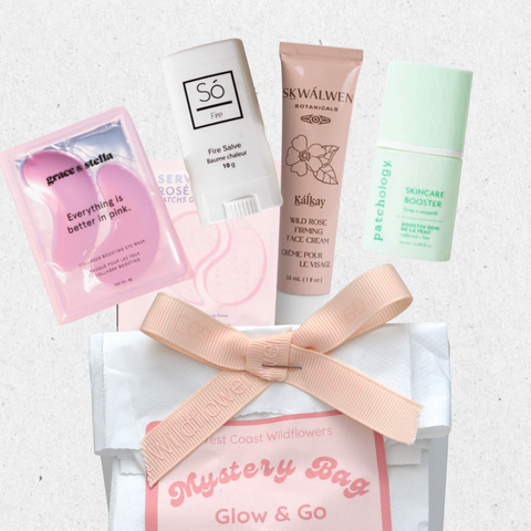 Mystery bag with skincare products and a pink ribbon on a light background