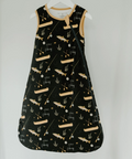 Black dress with beige patterns on a white hanger against a light gray background