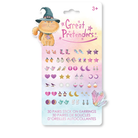A package of 'Great Pretenders' 3D stick-on earrings for kids, featuring a cute orange cat wearing a witch hat illustration on the card. The package contains 30 pairs of pastel-colored, whimsical earring charms shaped like stars, moons, hearts, and crystals, shown against a clean white background.