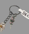Keychain with floral charms and a tag labeled 'DEC' on a light gray background