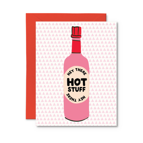 Greeting card with a pink bottle labeled 'Hey There Hot Stuff' on a patterned background