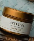 Voyageur Hollow Tree candle jar with gold lid on a textured surface