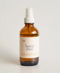 Brown spray bottle labeled 'Santal Dusk' on a light gray background