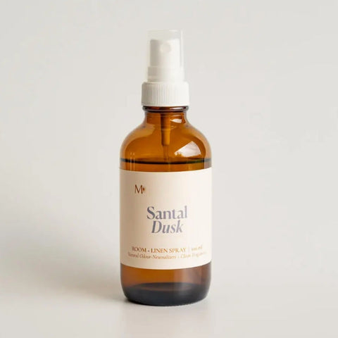 Brown spray bottle labeled 'Santal Dusk' on a light gray background