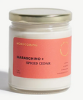 Candle jar with a pink label reading 'Maraschino + Spiced Cedar' on a white background