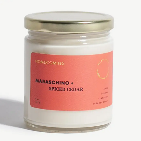 Candle jar with a pink label reading 'Maraschino + Spiced Cedar' on a white background