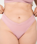 Person wearing a pink bikini set on a plain background