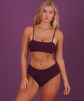 Woman wearing a purple bikini against a purple background