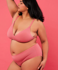 Woman wearing a pink bikini against a pink background