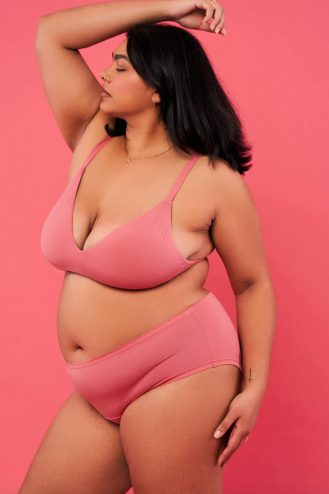 Woman wearing a pink bikini against a pink background