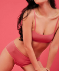 Woman wearing a pink bikini against a pink background