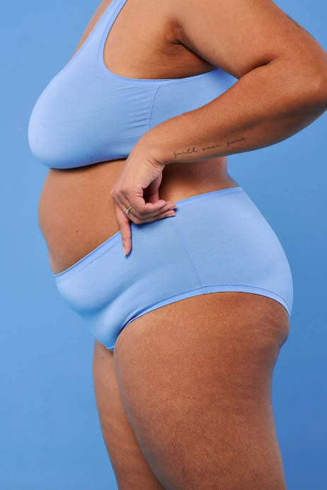 Person wearing a light blue bikini against a solid blue background