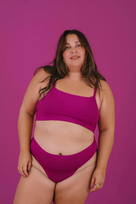 Woman wearing a pink bikini against a purple background