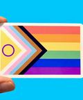 Colorful card with rainbow design held by a hand against a blue background