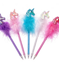 Five unicorn-themed gel pens with glittery unicorn heads, fluffy feather tops in purple, pink, blue, white, and magenta, and silver glitter barrels, arranged on a white background.