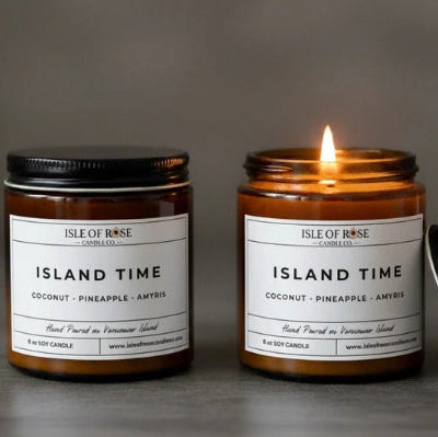 Two candles labeled 'Isle of Rose Island Time' on a gray background