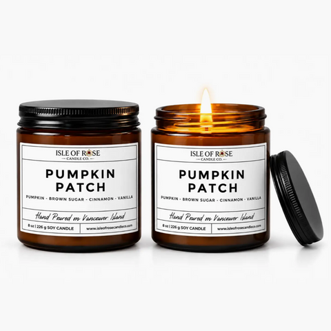 Two amber glass soy candles in black metal jars on a white background, one unlit and one lit with a visible flame. The labels read 'Isle of Rose Candle Co.