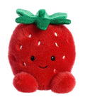 Plush strawberry toy with a smiling face on a white background