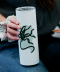 Person holding a white tumbler with a green dragon design.