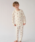 Child wearing a cream-colored pajama set with small patterns on a white background