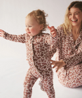 Woman and child in matching patterned pajamas on a white background