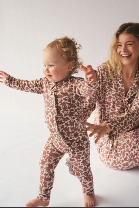Woman and child in matching patterned pajamas on a white background