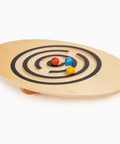 Wooden balance board with colorful balls on a white background