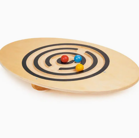 Wooden balance board with colorful balls on a white background