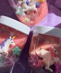 Decorative jars with unicorn figurines and glittery contents on a purple surface