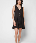 Woman wearing a black sleeveless dress with buttons on a white background