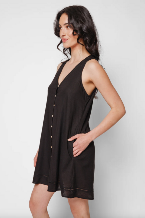 Woman wearing a black sleeveless dress against a white background