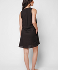 Woman wearing a black sleeveless dress against a white background