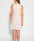 Woman wearing a beige sleeveless dress on a white background