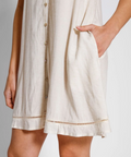 Beige dress with button details on a plain background