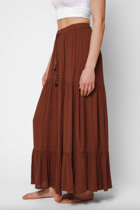 Brown tiered skirt worn by a person on a white background