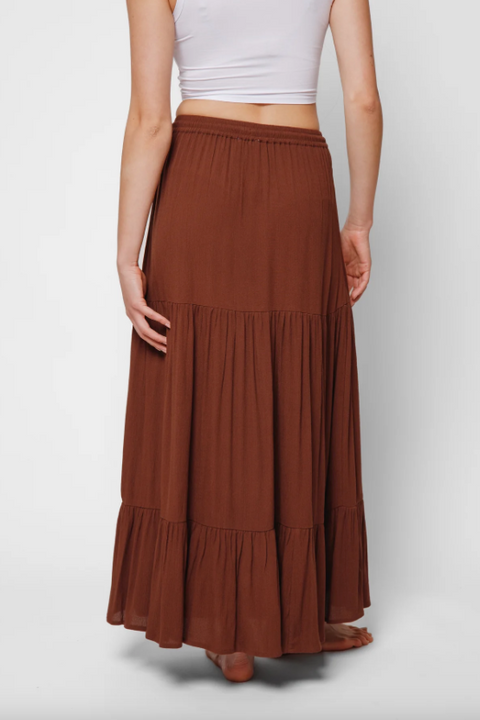 Brown tiered skirt worn by a person on a white background