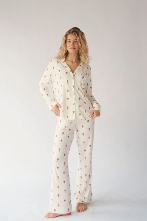 Woman wearing a white pajama set with small patterns on a plain background