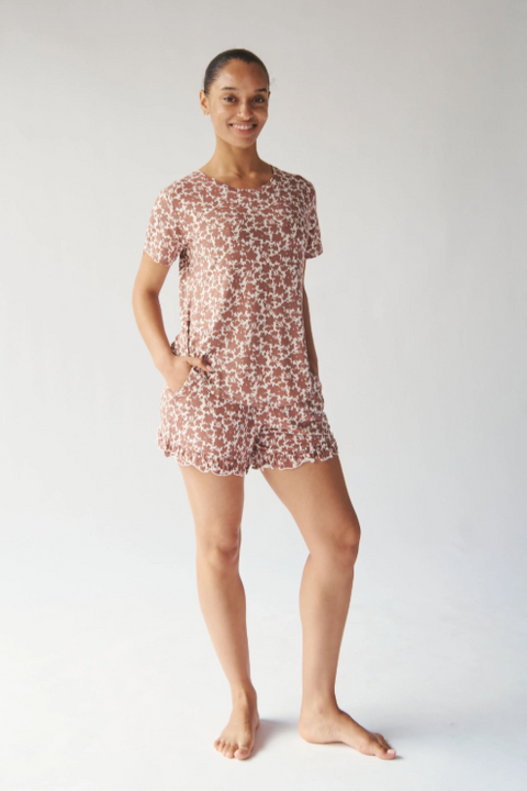 Woman wearing a floral pajama set on a white background