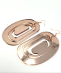 Large ovoid earring from Copper Canoe Woman in rose gold mirror acrylic with crescent cutout.