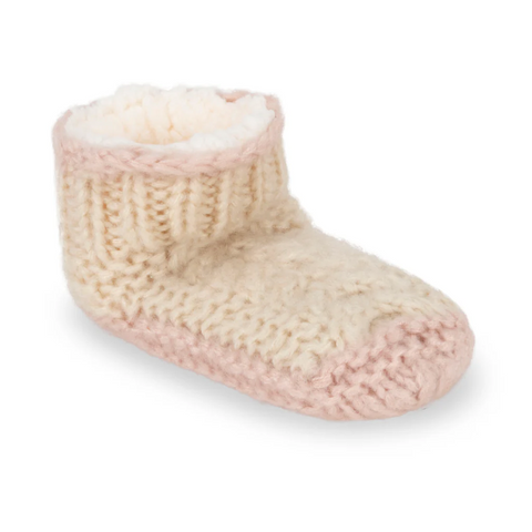 Knitted baby bootie with pink sole on a white background