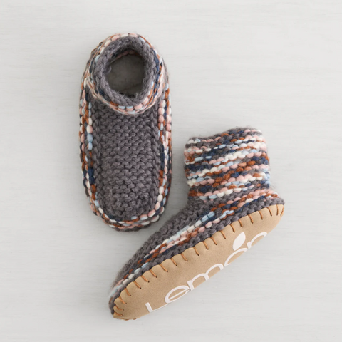 Pair of knitted baby boots with a brand logo on a light background