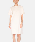 Woman wearing a white dress against a plain background