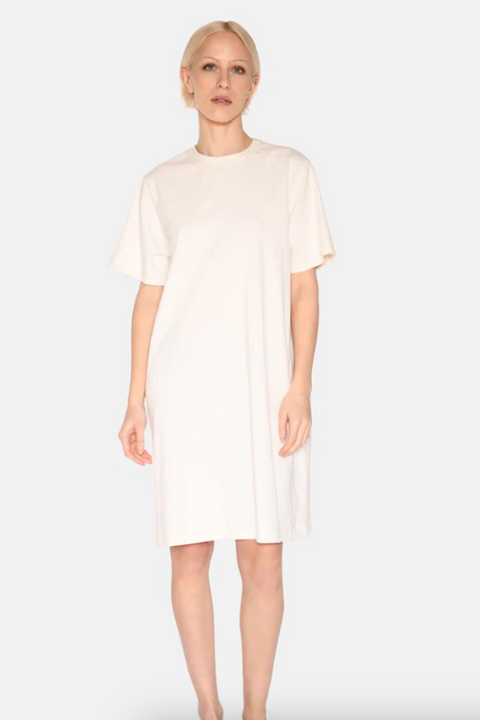 Woman wearing a white dress against a plain background