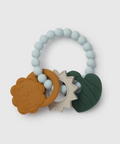 A baby teether toy with a light blue beaded ring, featuring three textured silicone shapes: a brown lion face ring, a beige sunburst ring, and a dark green leaf shape, on a light gray background.
