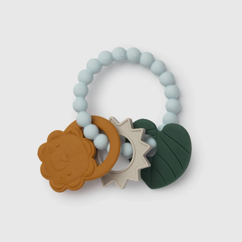 A baby teether toy with a light blue beaded ring, featuring three textured silicone shapes: a brown lion face ring, a beige sunburst ring, and a dark green leaf shape, on a light gray background.